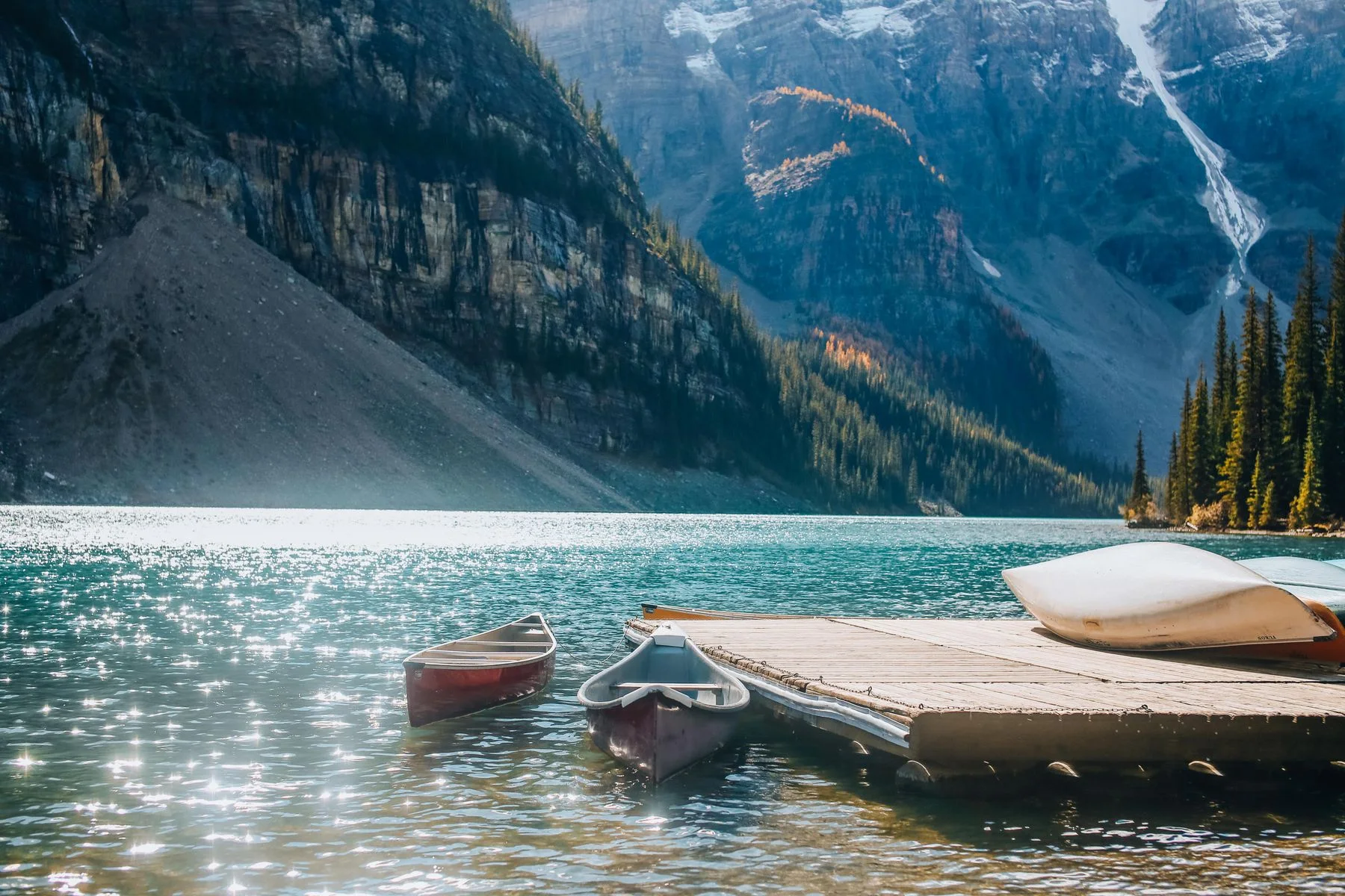 Canoes beside a pier on a mountain lake